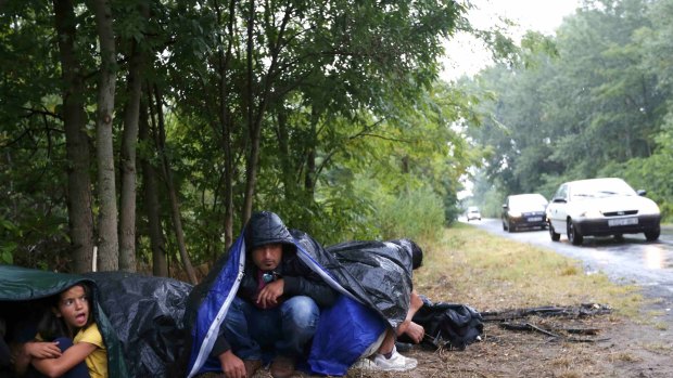 Migrants from Syria rest on the side of a road near Asotthalom, Hungary.