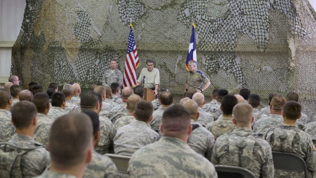 Former Texas Governor Rick Perry (centre) speaks at Camp Swift Army National Guard Training facility in 2014. Up to 1000 Texas National Guard troops were deployed to the Mexican border last year.