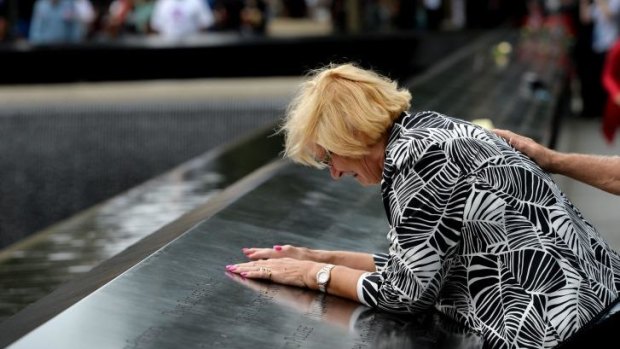 Paola Braut, of Belgium, kisses a photograph of her son Patrice along the edge of the North Pool during memorial observances on the 13th anniversary of the 9/11 terror attacks, at the site of the World Trade Centre in New York.