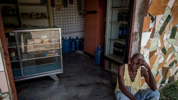 A man rests in front of a local store in Barlovento. The store has not received food since January, forcing people to go to bigger towns or even Caracas to shop. 