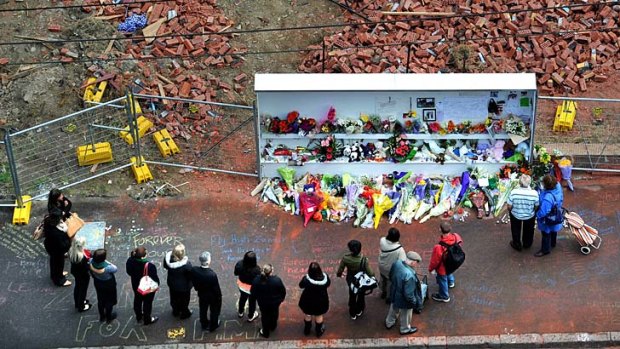 People pay their respects to the three wall victims on Tuesday.