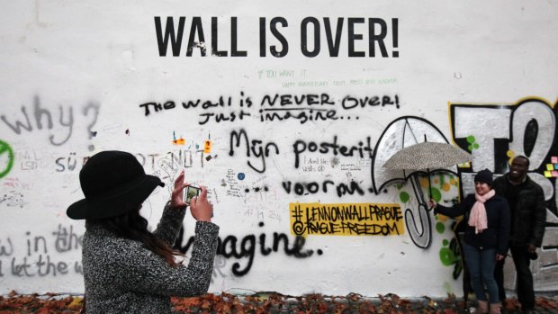 Tourists take pictures at the John Lennon Wall in Prague.