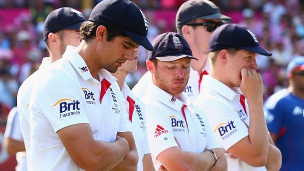 England captain Alastair Cook and his teammates stand with heads bowed during the presentation.