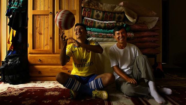 Second family: Auburn United FC coach Essa Khan, right, and asylum seeker Mohammad Jawad Mohammad Jawad, pictured in his favourite Arsenal jersey, both fled Afghanistan.
