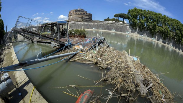A boarding pier and shores dotted with waste in front of Castel Sant' Angelo at the entrance of  "Ships of Rome", the tourist service on the city's Tiber.