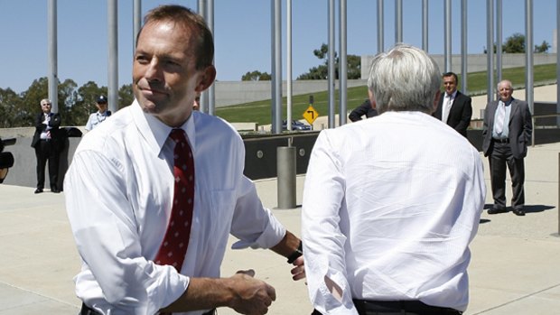 Gazumped ... the Prime Minister leaves a protest outside Parliament yesterday, having arrived unannounced with a pen and notebook to listen to members of the insulation industry, as the Opposition Leader, Tony Abbott, arrives to hear their complaints.