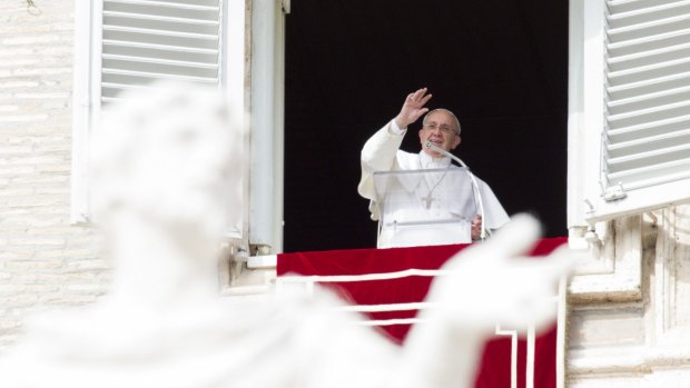 Pope Francis waves to faithful from his studio window overlooking St Peter's Square on Sunday.