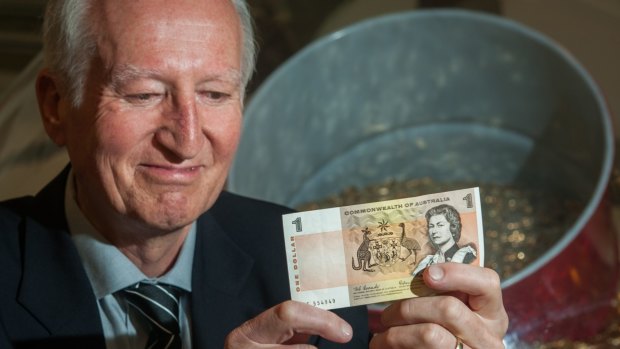 Canberra author Peter Rees at the Royal Australian Mint with a $1 note he received in his first pay packet in the same week Australia converted to decimal currency.
