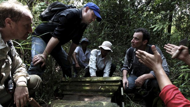 Rock gods: Australian archaeologist Damian Evans (blue cap) inspects a find with Jean-Baptiste Chevance (kneeling on the right) in Cambodia.