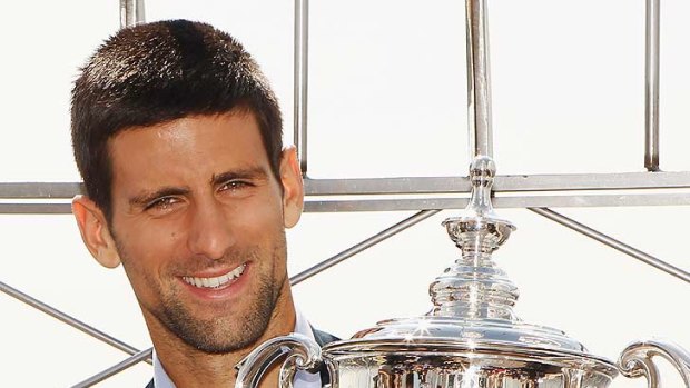 US Open Singles Men's Champion Novak Djokovic poses with his trophy atop the Empire State Building.
