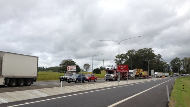 Trucks and cars line -up along the Bruce Highway in the northbound lane with the highway closed due to flooding near Gympie.