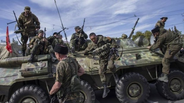 Pro-Russian rebels jump off an armored personnel carrier (APC) during a parade in Luhanks, eastern Ukraine.