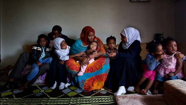 Shamsun Ali and Filsan Warsame with their seven children in their two-bedroom apartment.