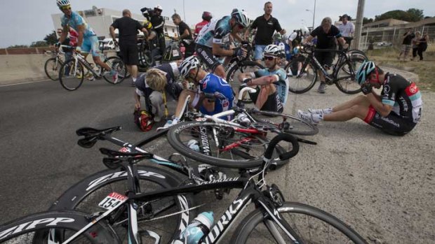 Murilo Antoniobil Fischer of Brazil, center left, Tony Martin of Germany, center right, and Tony Gallopin of France, right, wait for medical assistance after crashing in the last kilometers of the first stage of the Tour de France.