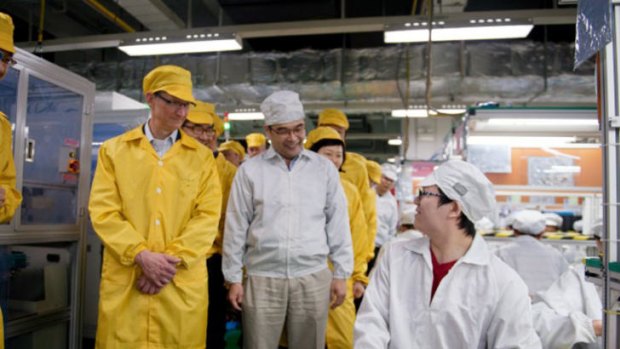 Apple CEO Tim Cook, left, visits the iPhone production line at the newly-built manufacturing facility Foxconn Zhengzhou Technology Park, which employs 120,000 people.