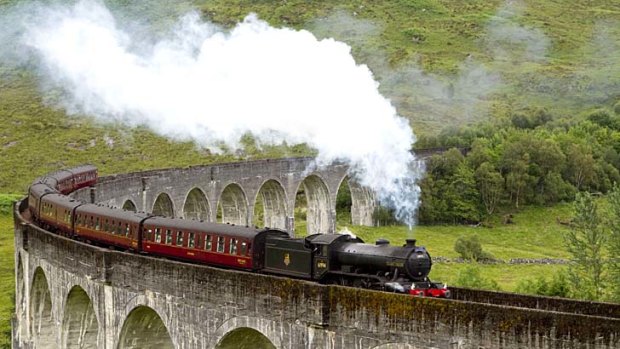The Jacobite steam train crosses the Glenfinnan Viaduct at the head of Loch Shiel.