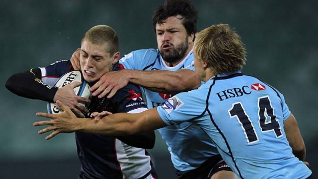 Comin' through: Rebel James O'Connor tries to break some Waratahs tackles.