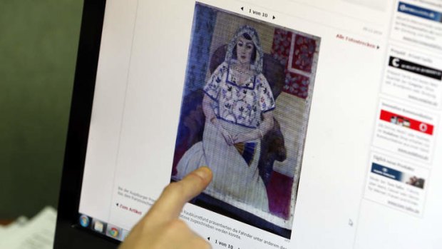 A researcher of the Art Loss Register at their offices in central London points to a picture showing a painting by Henry Matisse entitled 'Sitzende Frau', part of the art recently found in Munich, Germany.