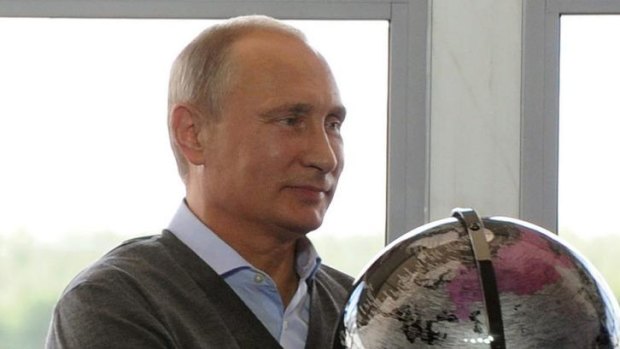 Russian President Vladimir Putin holds a globe presented him as a gift during his meeting with participants in the youth educational forum near Lake Seliger in Russia.