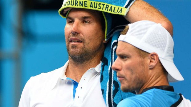 Pat Rafter and doubles partner Lleyton Hewitt look on during their first round men's doubles match.