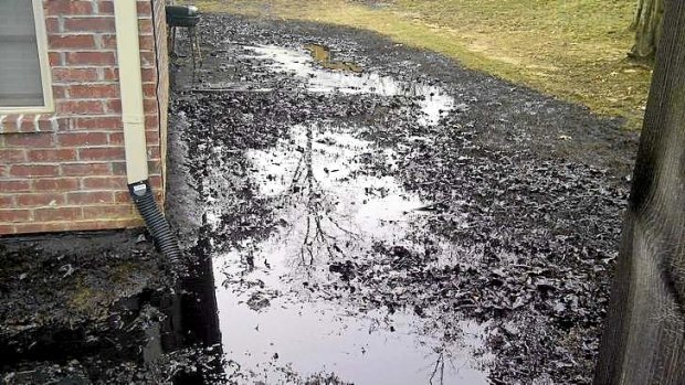 Spilt oil from Exxon pipeline runs between homes in Mayflower, Arkansas.