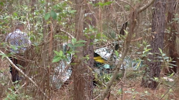 Crews inspect the wreckage of an ultralight aircraft which crashed north of Caboolture on Monday claiming the life of the female pilot.