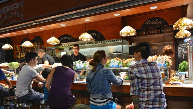 Barcelona: customers seated at a tapas bar at La Boqueria market in Barcelona, Spain. 