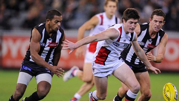 Backhander: Collingwood's Leon Davis (left) and Luke Ball are in hot pursuit of St Kilda's Tom Ledger during a match in which the Saints lost their momentum.