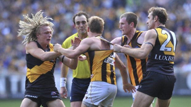 Richmond and Hawthorn players get physical as umpire Troy Pannell (in lime green) looks on.