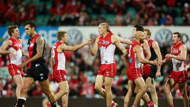 Flying high: Swans players celebrate with Sam Reid after another major against Essendon.