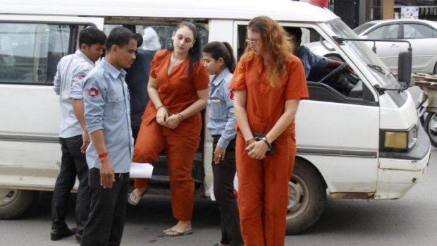 Australian Ann Yoshe Taylor, right, and French teen Charlene Savarino get off a bus at the Phnom Penh Municipal Court in Phnom Penh, Cambodia.