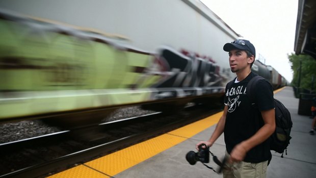 Stephen Schmidt, 18, a young train enthusiast, watches a passing train.