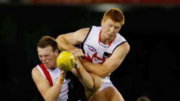 Brendon Goddard of the Saints is tackled by Kyle Cheney of the Demons during the round 14 match at Etihad Stadium.