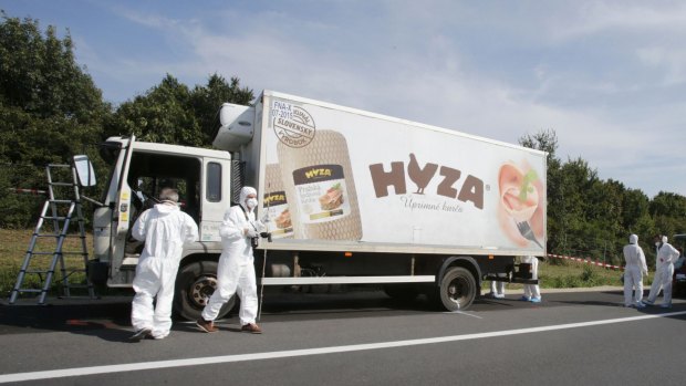Forensic police officers inspect the truck parked on an Austrian highway.