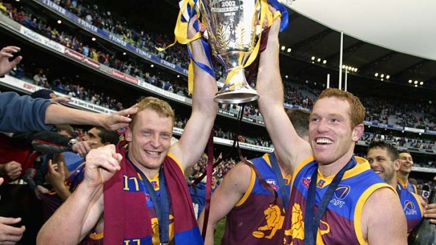 Lions stars Michael Voss and Justin Leppitsch celebrate with the 2002 premiership cup.