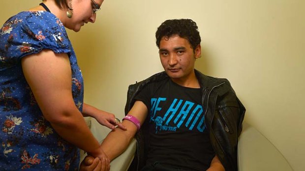 Nurse Katherine Rule takes blood from Afghan asylum seeker Gulistan Hussaini, 28.