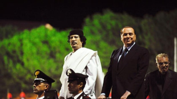 Side by side ... Muammar Gadaffi, left, and Silvio Berlusconi arrive at an Italy-Libya friendship celebration during Mr Gadaffi’s two-day visit.