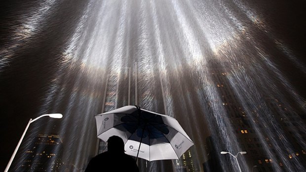 A worker holds an umbrella while adjusting beams of the Tribute in Lights ahead of the 10th anniversary of the September 11 terrorist attacks in New York City.