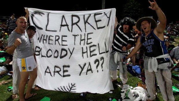 Fans hold up a banner referring to Michael Clarke's decision to quit the tour of New Zealand.
