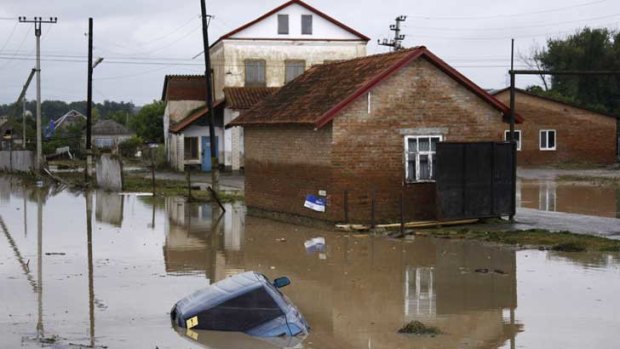 A car lies submerged in a flooded street in the village of Novoukrainsk, near the southern Russian town of Krymsk.