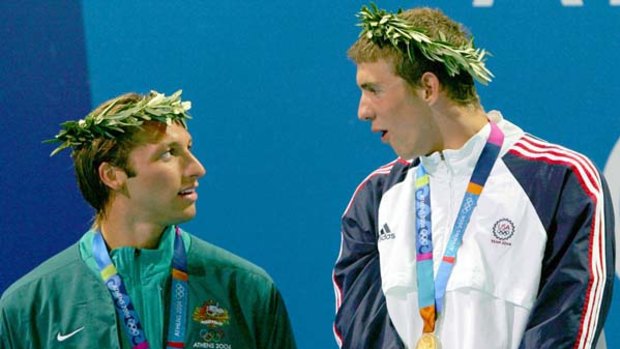 Michael Phelps of the US looks down on Ian Thorpe at the medal ceremony for the men's 4 x 200 metre freestyle relay at the Athens Olympics.