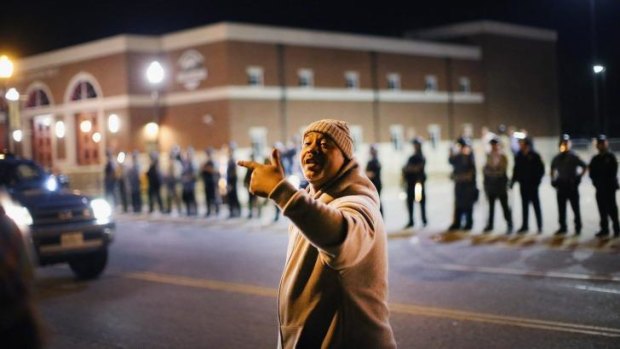 Police face off with demonstrators outside the police station as protests continue in the wake of the police shooting death of 18-year-old Michael Brown.