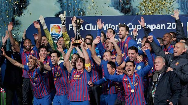 Barcelona captain Carles Puyol (fourth from left) lifts the trophy as he and his teammates celebrate after winning the Club World Cup.