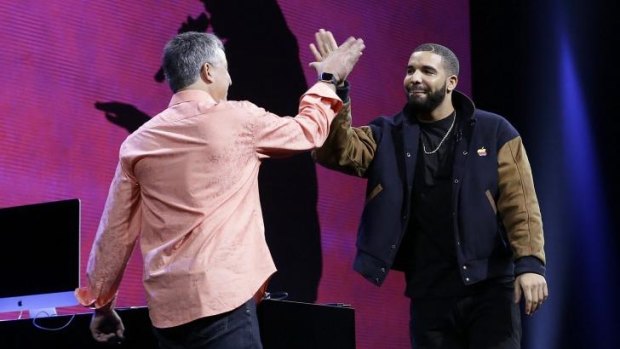 Canadian rapper Drake high-fives Eddy Cue, Apple senior vice president of Internet Software and Services.