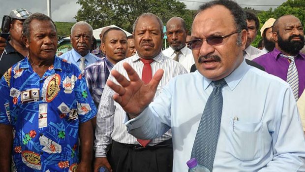 Papua New Guinean Prime Minister Peter O'Neill (right) addresses the crowd outside Government House in Port Moresby.