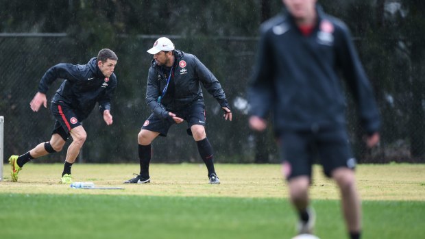 Always working: Wanderers coach Tony Popovic puts Scott Neville through his paces on the training track.