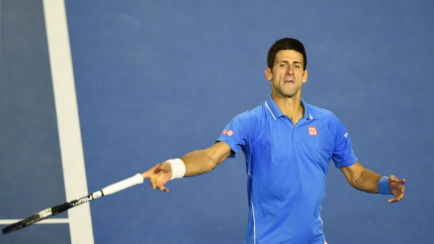 Serbia's Novak Djokovic throws his racquet into the crowd as he celebrates after his victory.
