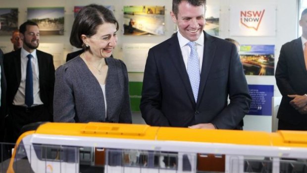 All aboard: Mr Baird and Ms Berejiklian study a model of the new trains.