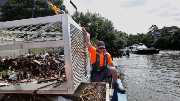 Troubled waters ... Paul Skimmings on a Maritime NSW cleaning vessel on the Parramatta River, removing rubbish after heavy rainfall.