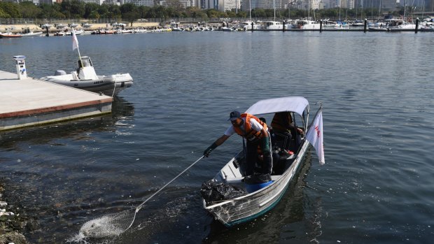 Rubbish is cleared from the water at the Marina da Gloria sailing venue on August 2, in Rio de Janeiro.